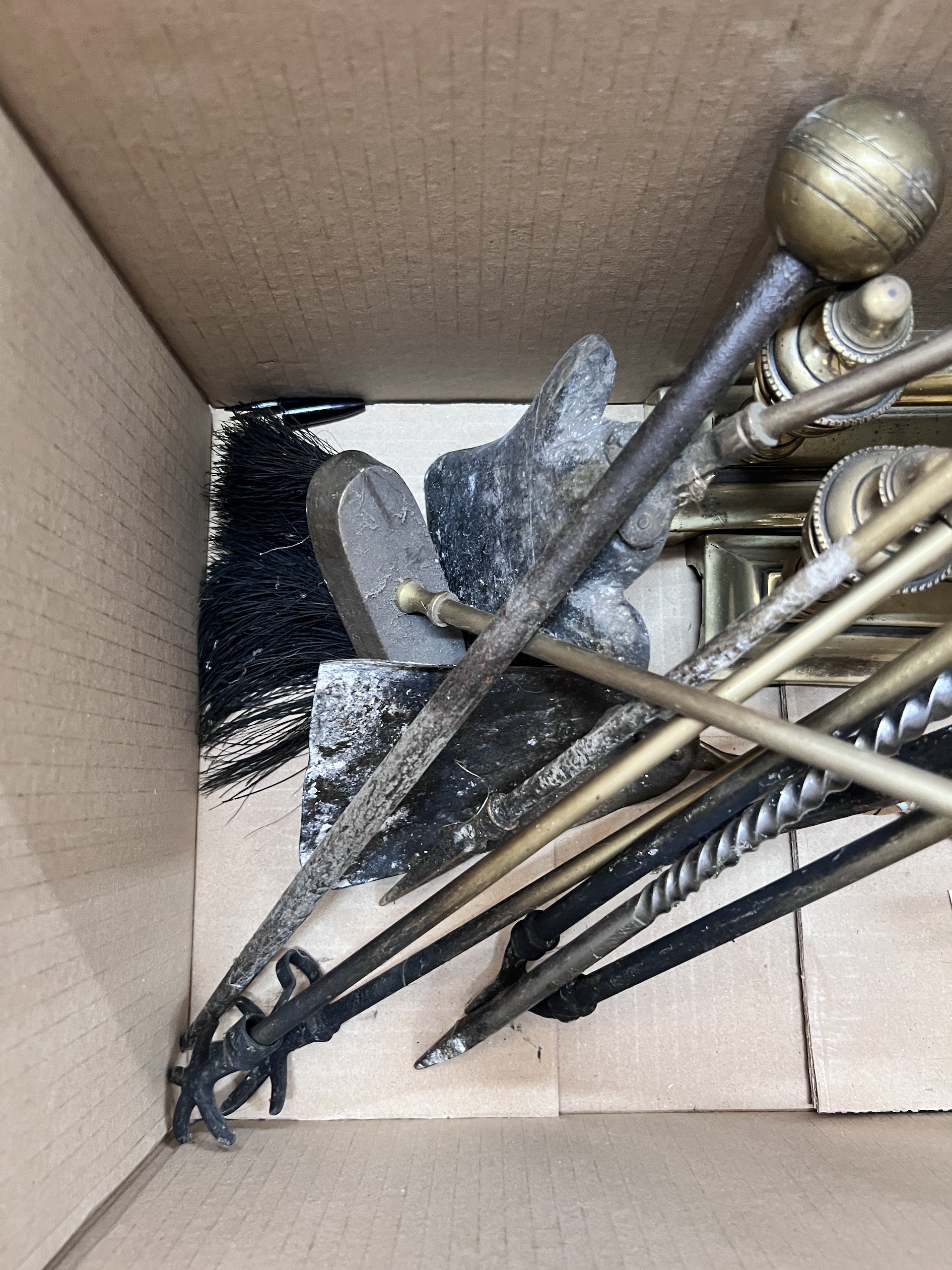 A collection of assorted fire implements and a pair of brass fire dogs